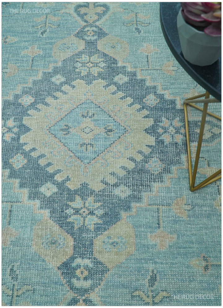 Hand-knotted wool area rug with blue and beige geometric pattern in diagonal view