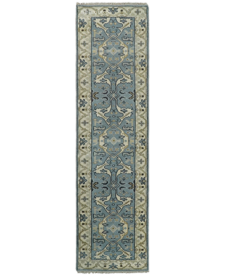 Hand-knotted wool runner rug with blue-gray floral motifs and beige borders