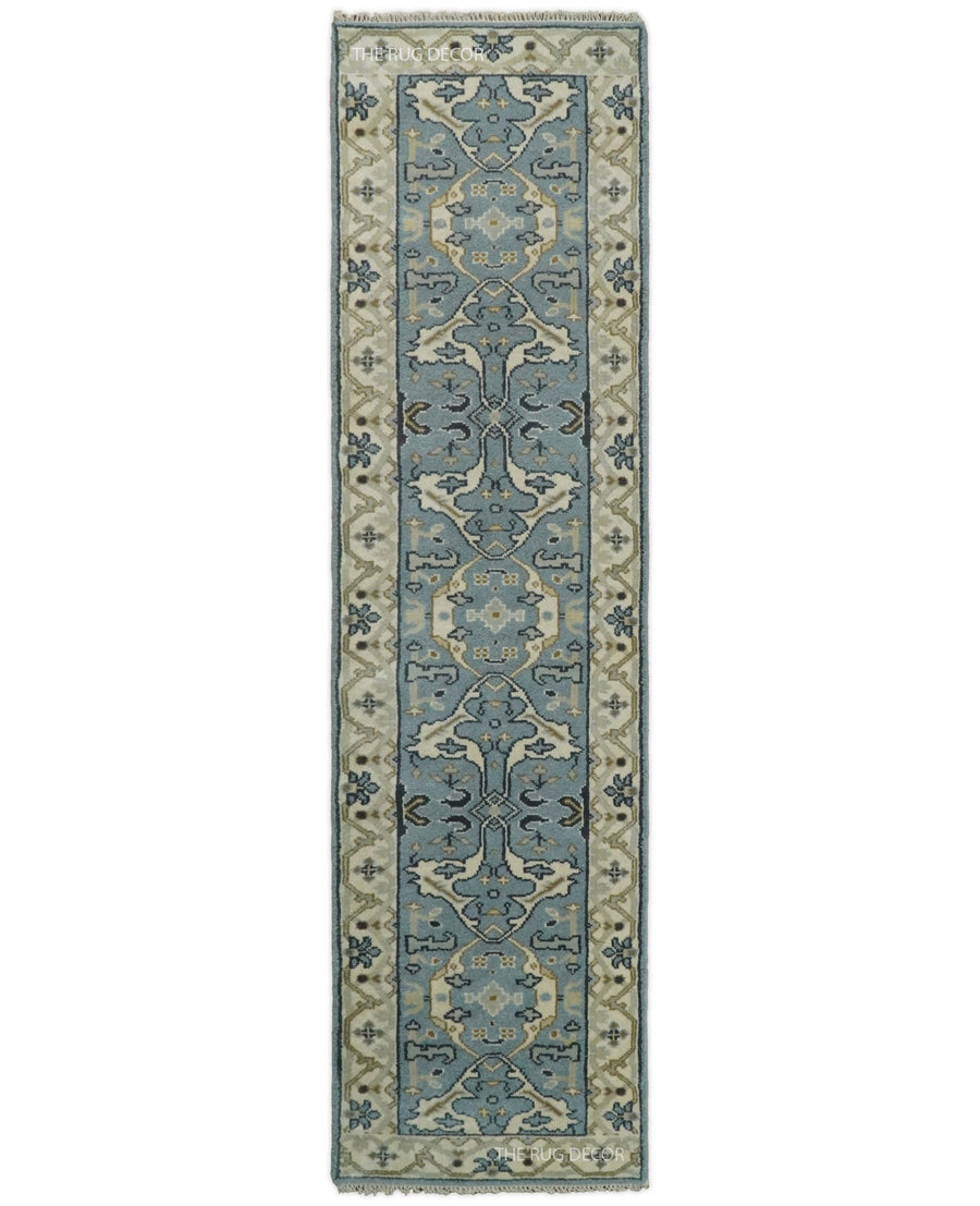 Hand-knotted wool runner rug with blue-gray floral motifs and beige borders