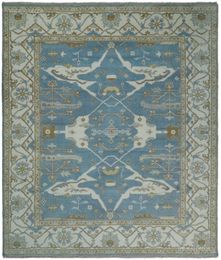 Blue and ivory hand-knotted wool Oushak rug with an ornate floral medallion and border
