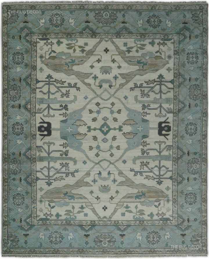 Blue and ivory hand-knotted wool Oushak rug with an ornate floral medallion and border