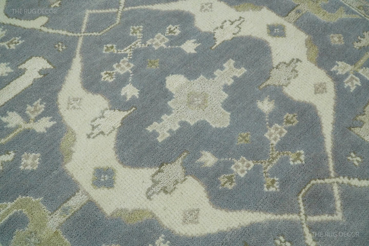 Close-up of blue-gray and ivory traditional rug pattern with textured, dense pile.