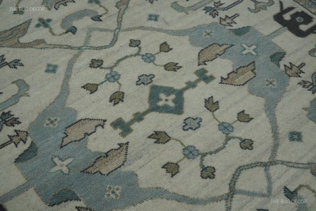 Close-up of the rug's ivory field with blue and taupe floral motifs