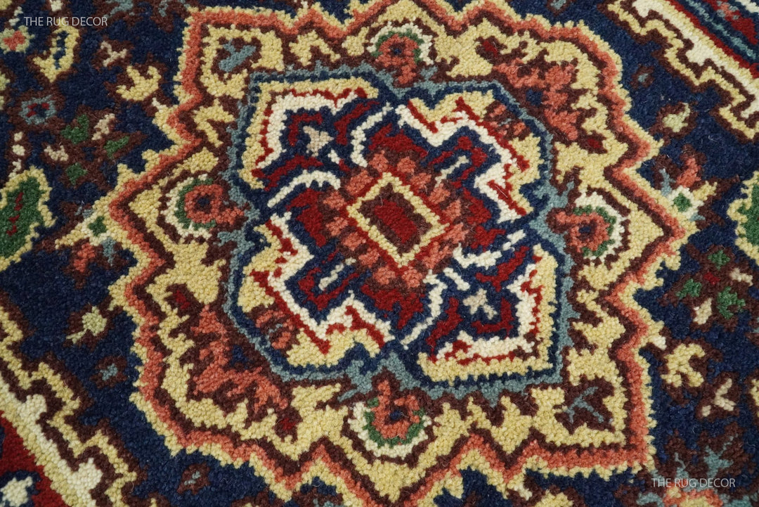 Close-up of the runner rug's hand-knotted geometric wool pattern in red, cream, and dark blue