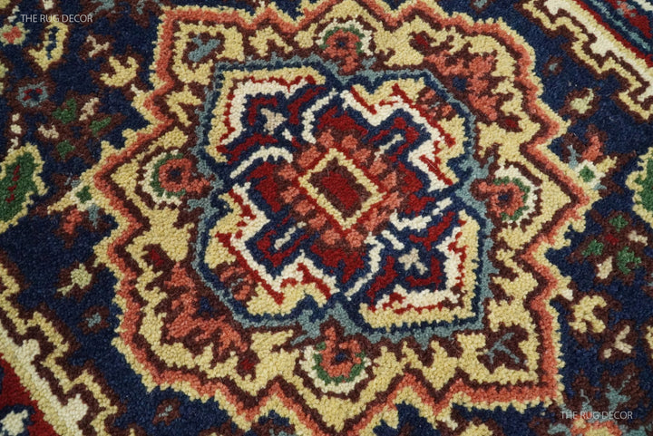 Close-up of the runner rug's hand-knotted geometric wool pattern in red, cream, and dark blue