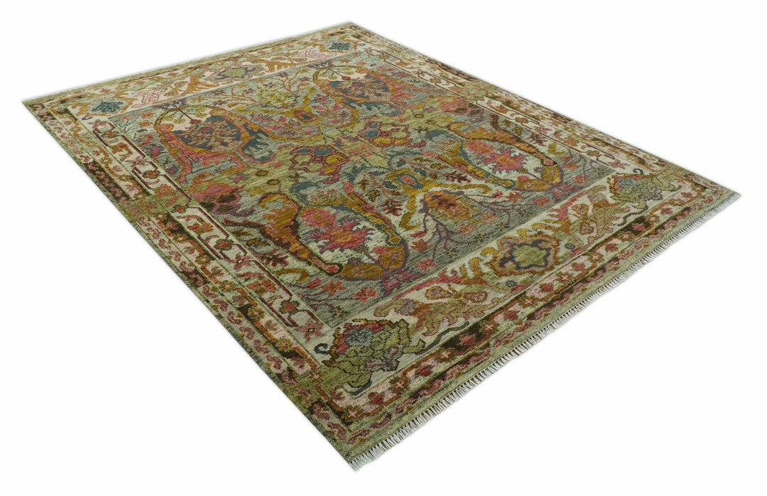 Hand-knotted wool rug with ornate green, gold, and rust pattern and short fringe