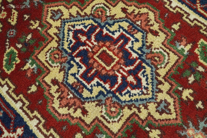 Close-up of the rug's red wool pile and intricate blue, cream, and green medallion