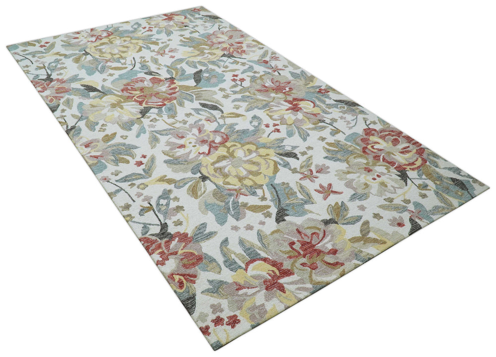 Hand-tufted wool area rug, ivory background with colorful floral vines, angled view