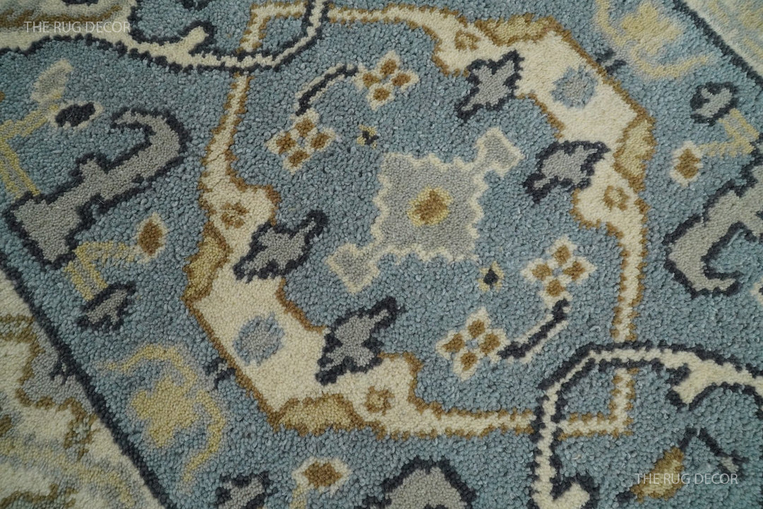 Wool runner rug close-up showing blue-gray pile and beige floral medallions