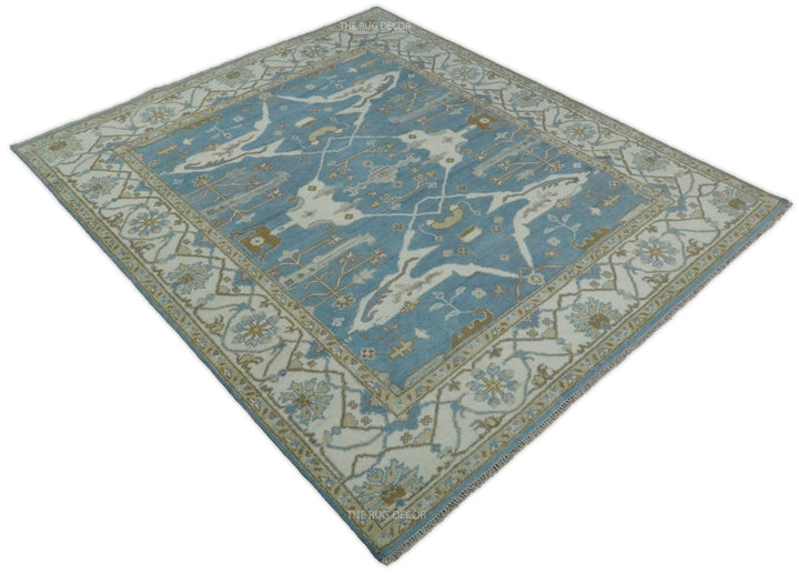 Blue and ivory hand-knotted wool rug shown at an angle, with a central medallion and floral border