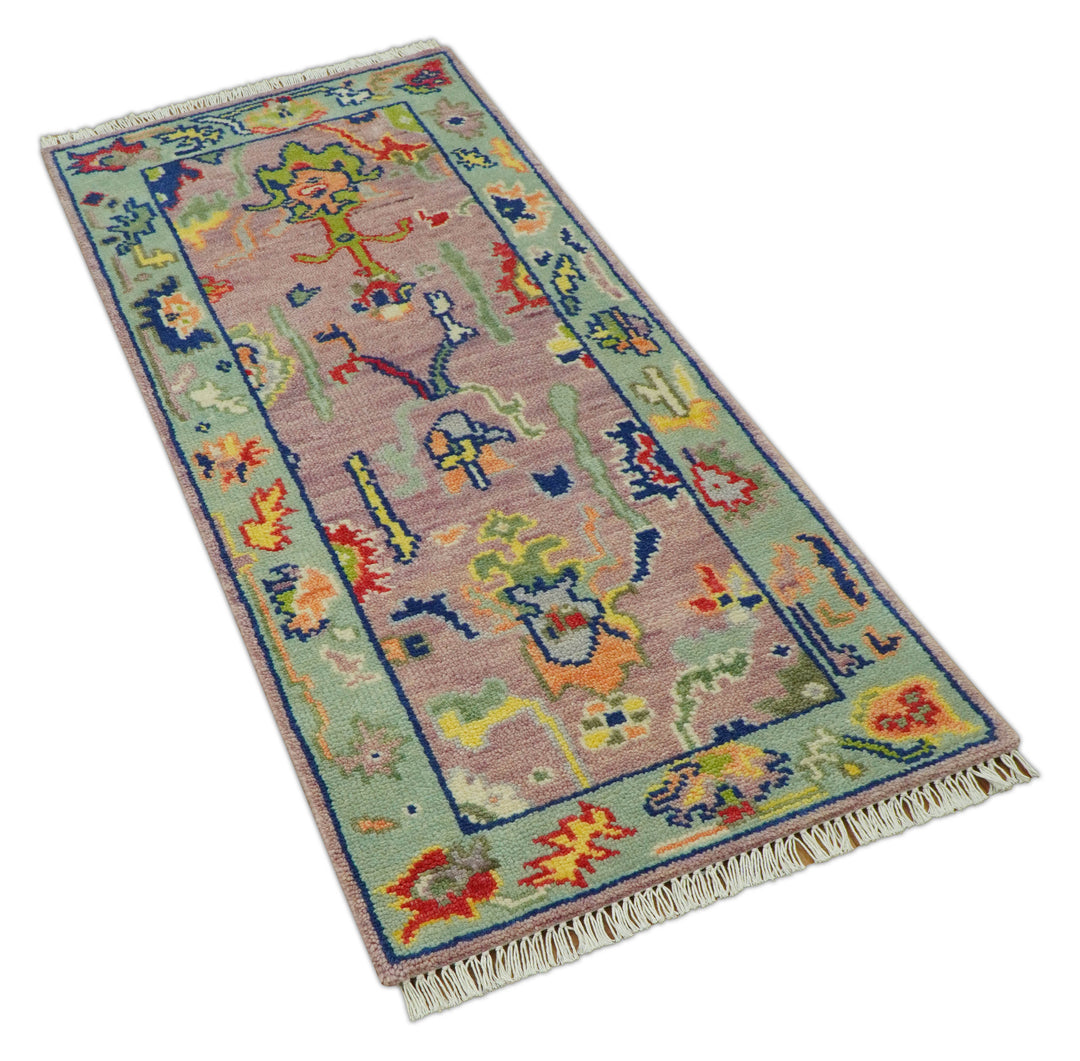 Traditional Oushak wool rug, pastel pink background with blue border and colorful medallion