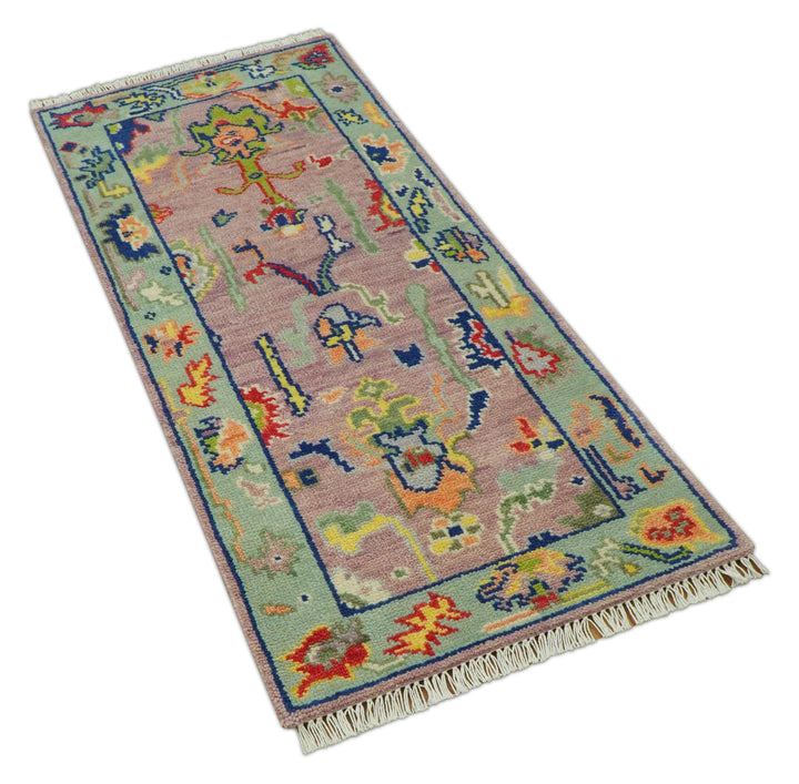 Traditional Oushak wool rug, pastel pink background with blue border and colorful medallion