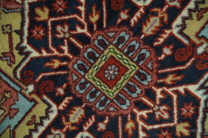 Hand-knotted rug detail showing dense red, blue, cream, and green geometric motifs