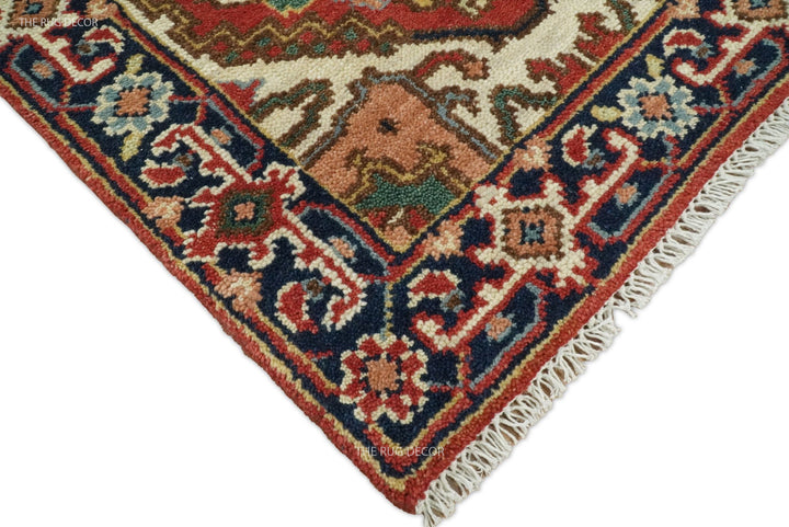 Wool runner rug corner showing its intricate blue and rust border and cream fringe