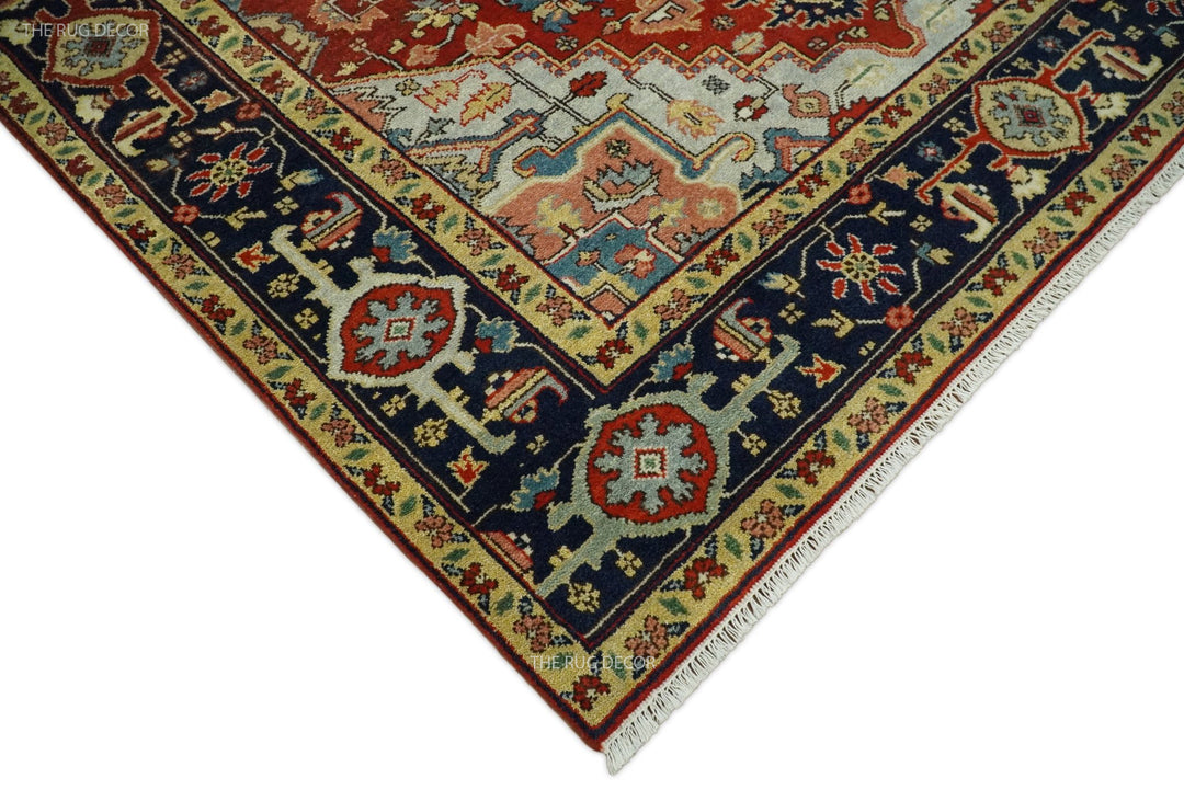Corner of red and blue traditional medallion hand-knotted wool rug with fringe