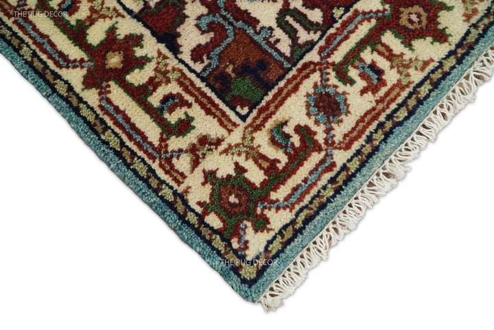 Rug corner showing an ivory fringe, blue edge, and ornate border
