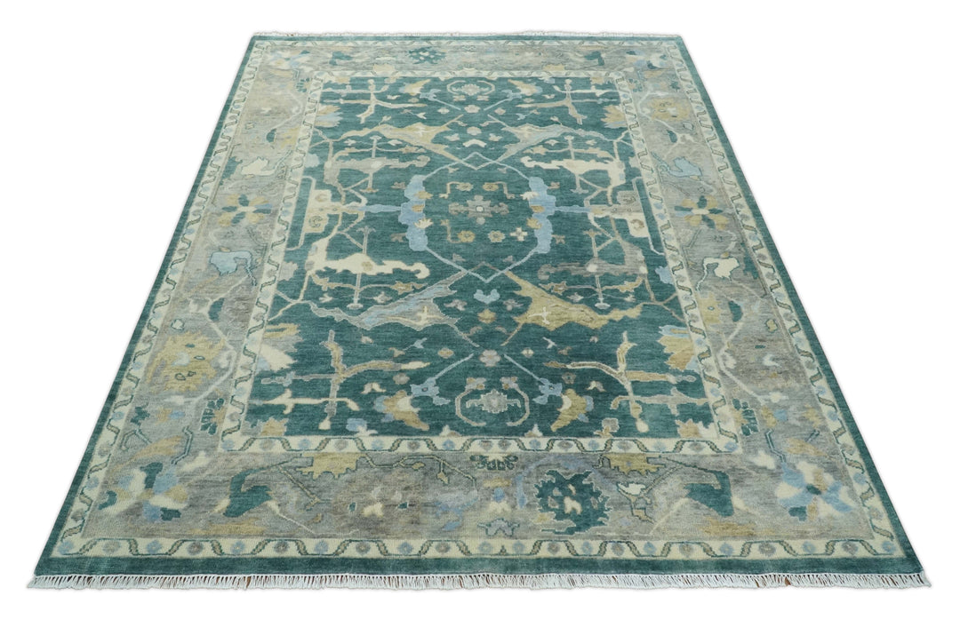 Teal and beige Oushak area rug featuring central medallion and ornate border pattern.