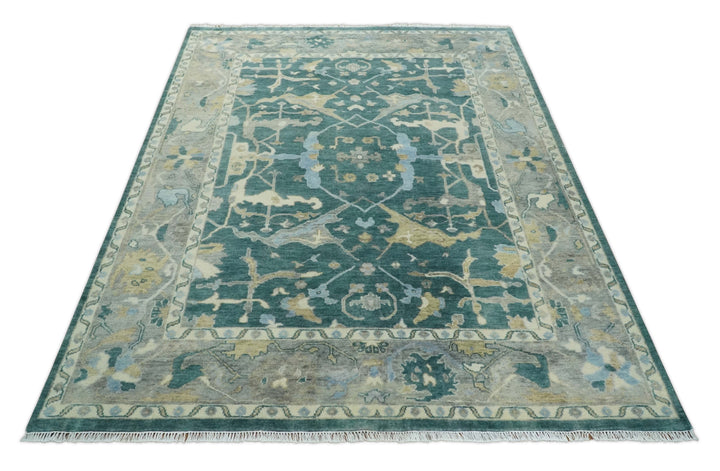 Teal and beige Oushak area rug featuring central medallion and ornate border pattern.