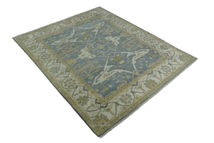 Full view of a rectangular gray and beige Oushak rug with an ornate border