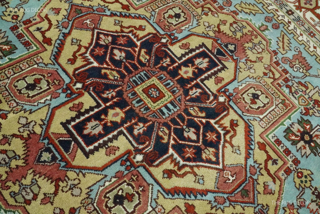 Close-up of the rug's ornate central medallion in blue, red, ivory, and green