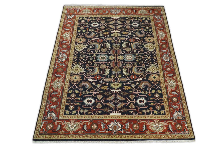 Full view of a traditional rug with a navy center and red patterned border