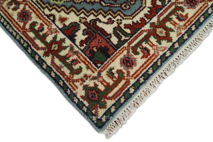 Wool runner rug corner with ivory fringe and ornate blue and rust border