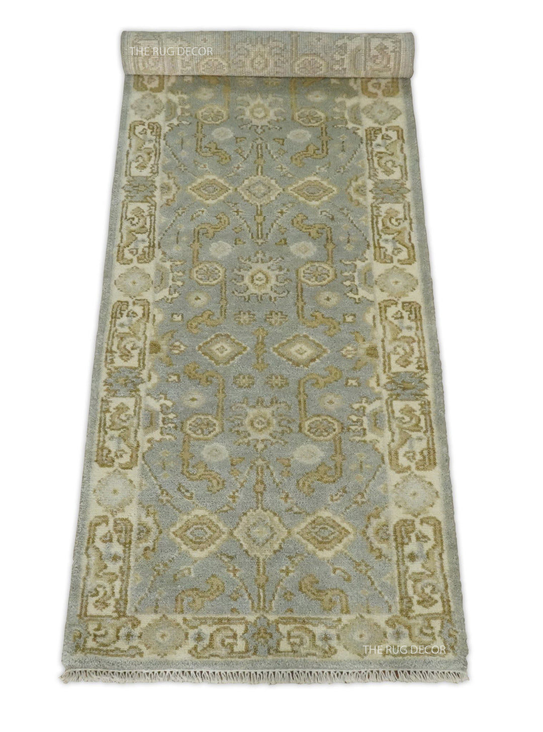 Gray and beige wool runner rug partially rolled to show its pattern and fringe