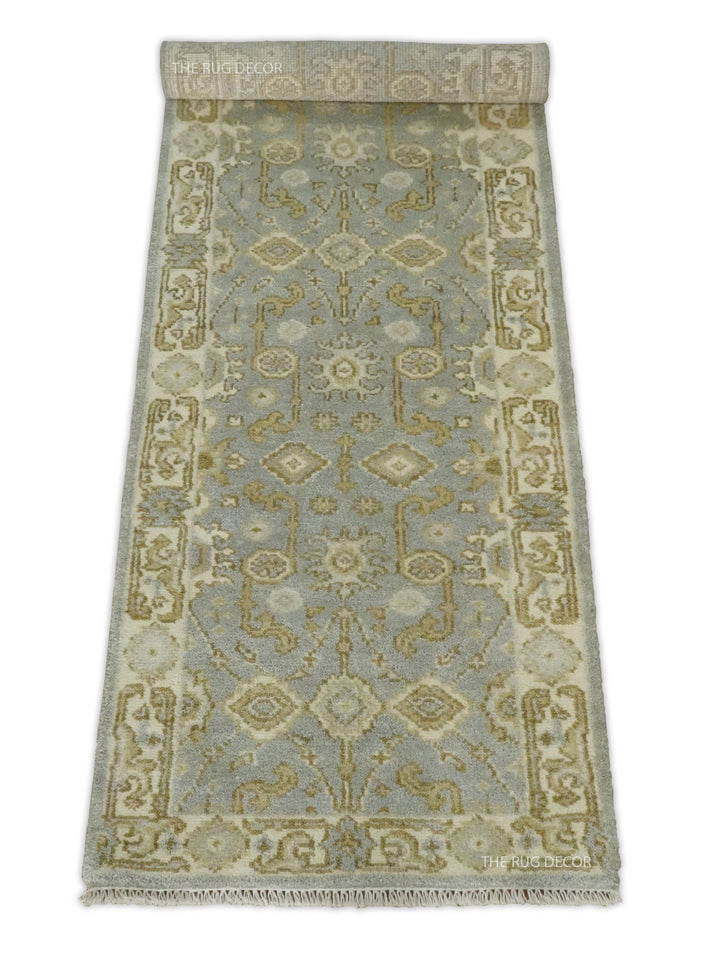 Gray and beige wool runner rug partially rolled to show its pattern and fringe