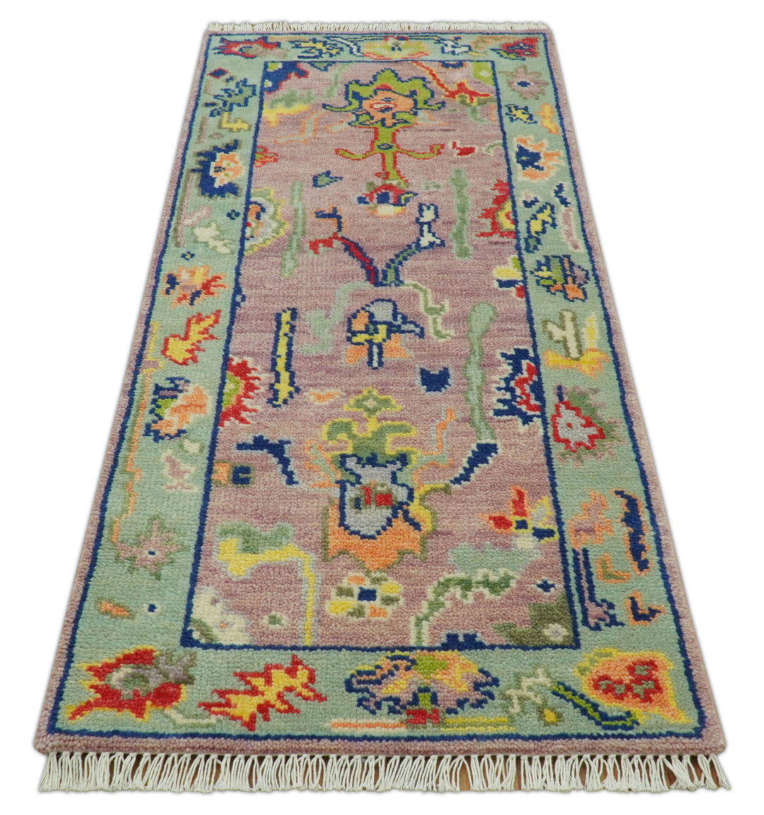 Traditional Oushak wool rug with pastel pink field, multicolor motifs, and short fringe