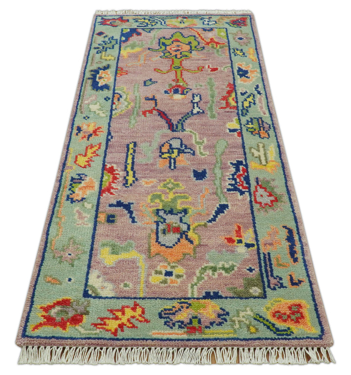Traditional Oushak wool rug with pastel pink field, multicolor motifs, and short fringe