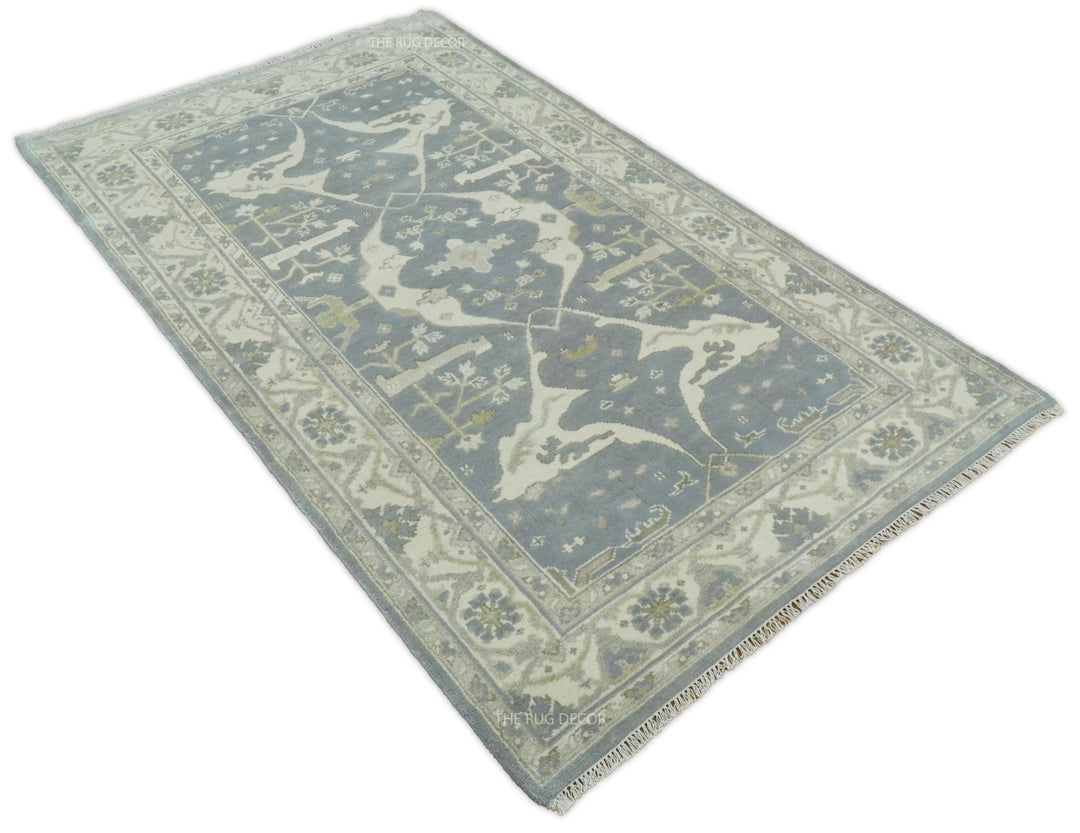 Rectangular traditional rug in blue-gray and ivory with detailed corner and central medallion.
