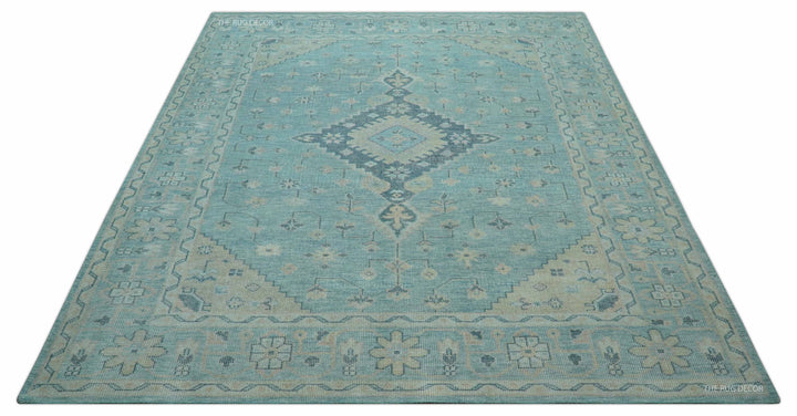 Hand-knotted wool area rug featuring blue background with beige medallion and side borders
