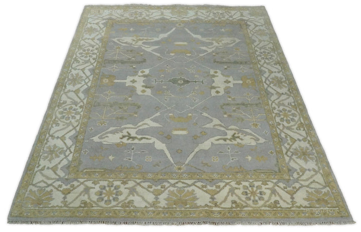 Gray and ivory wool rug with symmetrical central design and wide floral border