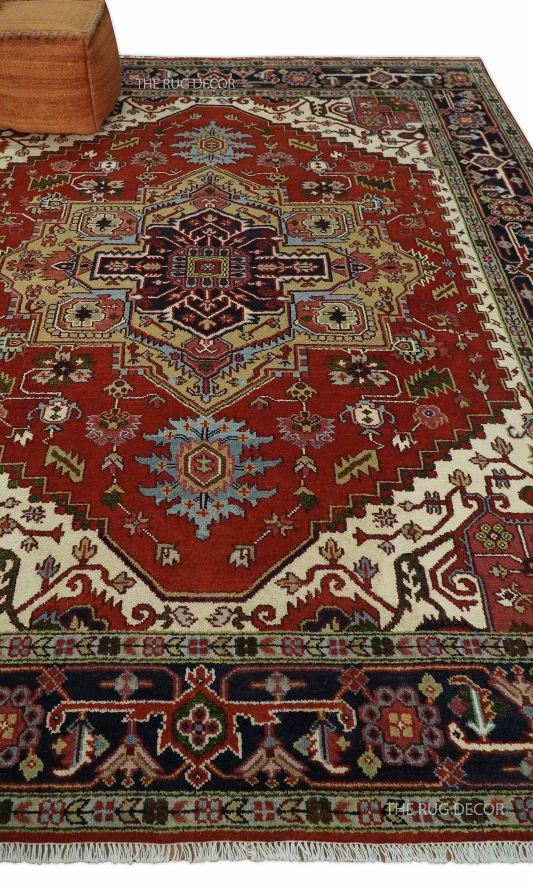 Red and blue Serapi rug displayed on the floor, showing its central medallion and fringed edge