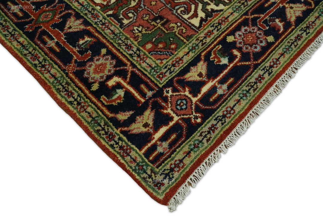 Rug corner with fringed edge and dark blue geometric motifs on rust red and cream background