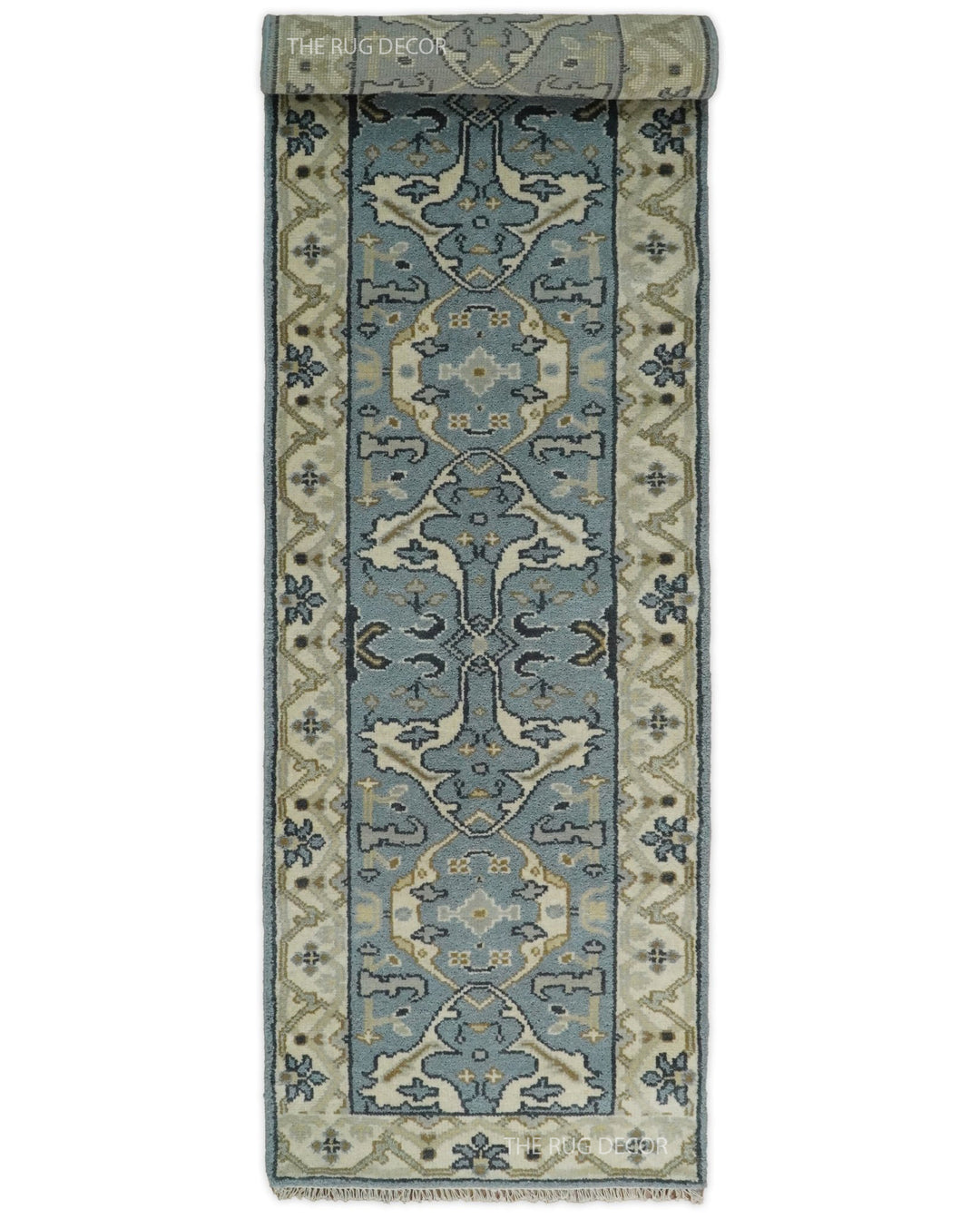 Blue-gray and beige wool runner rug, partially rolled to show its pattern
