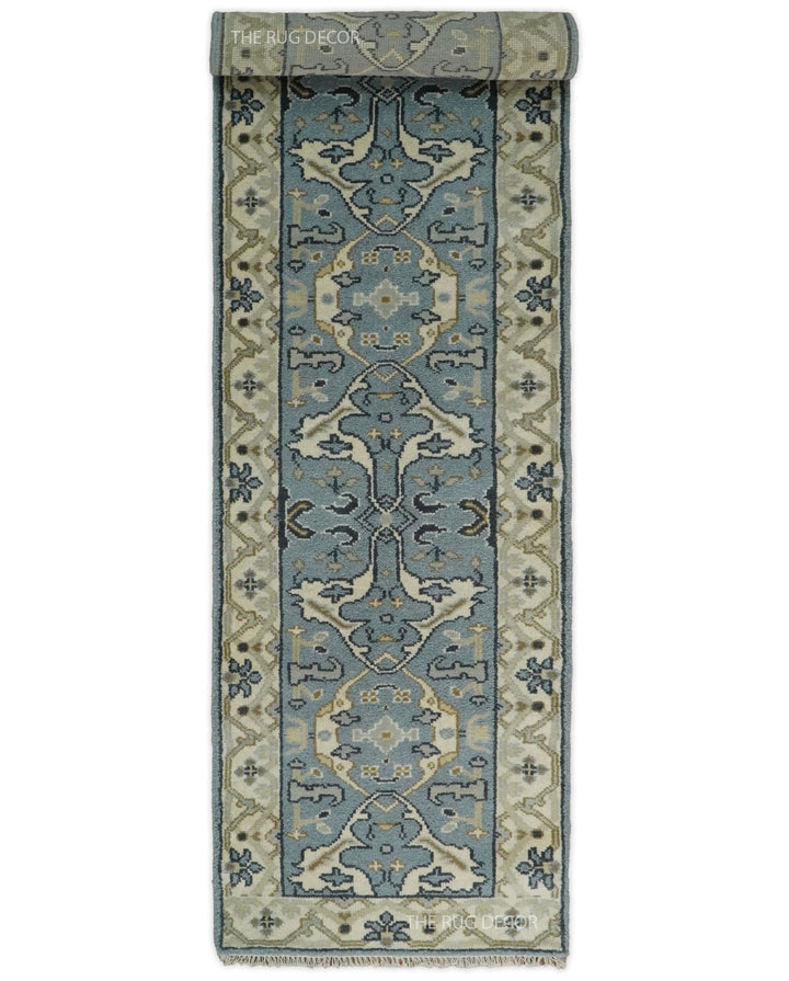 Blue-gray and beige wool runner rug, partially rolled to show its pattern