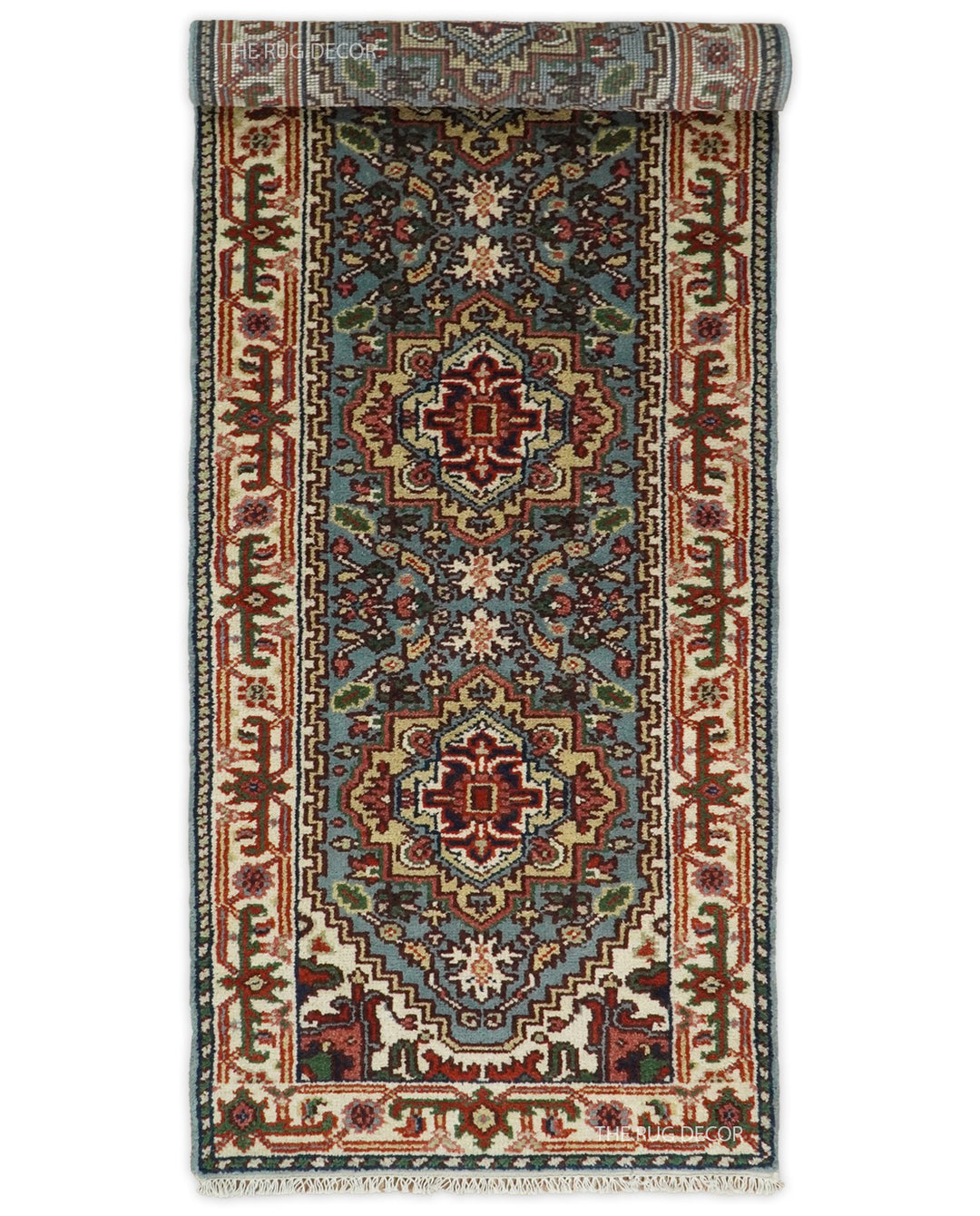 Blue and ivory wool runner rug shown partially rolled, with traditional medallions