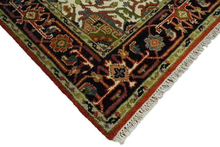 Corner detail of hand-knotted wool rug with fringed edge and olive-rust motifs