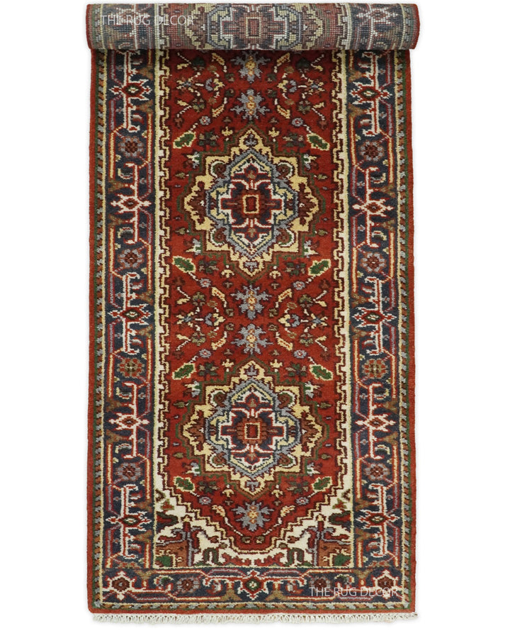 Sera Runner rug partially rolled to show its red field and ornate border