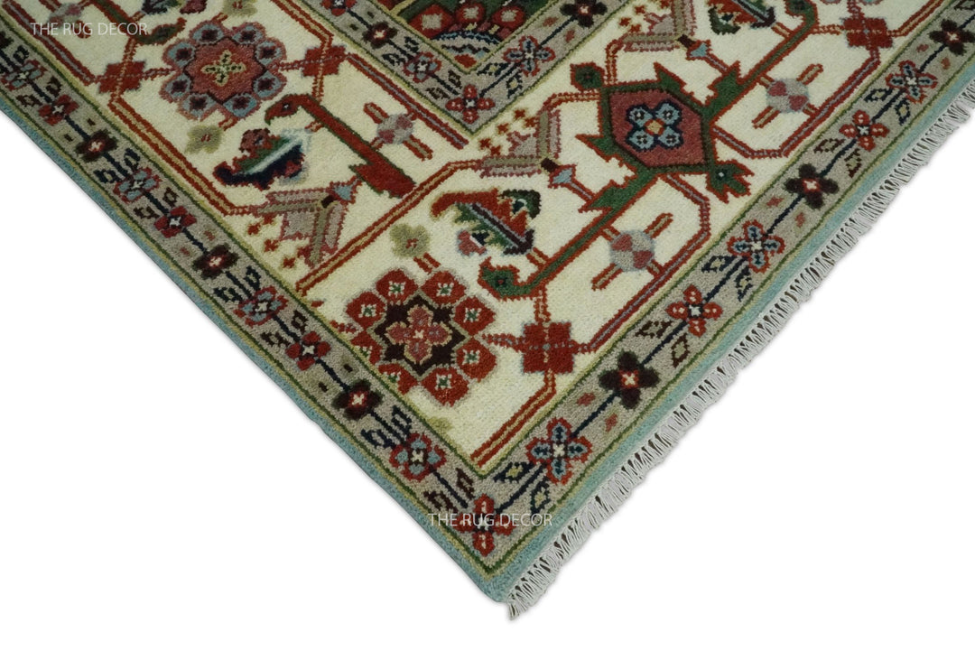 Rug corner showing an ivory floral border, blue edge, and short fringe
