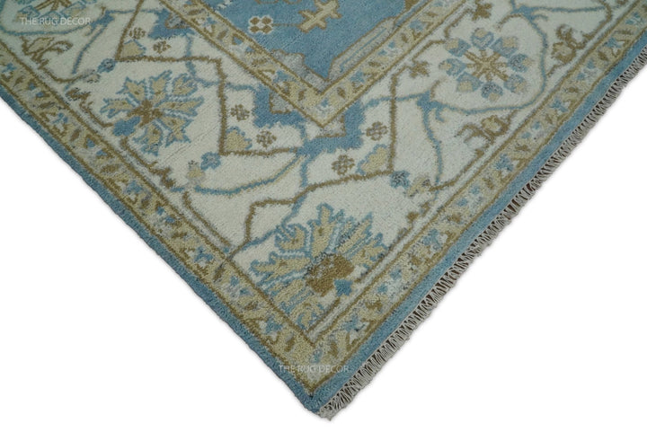 Ivory floral border, blue edging, and fringe at the corner of the wool rug