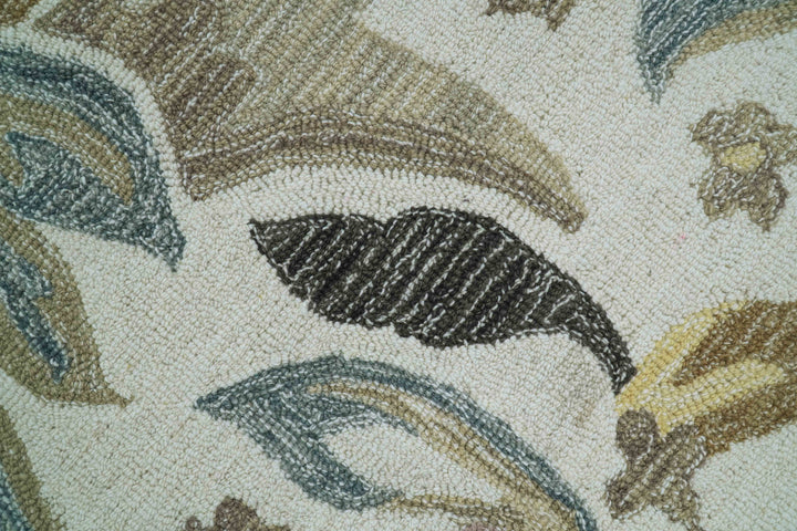 Close-up of hand-tufted wool rug texture with leafy motif in dark outlines