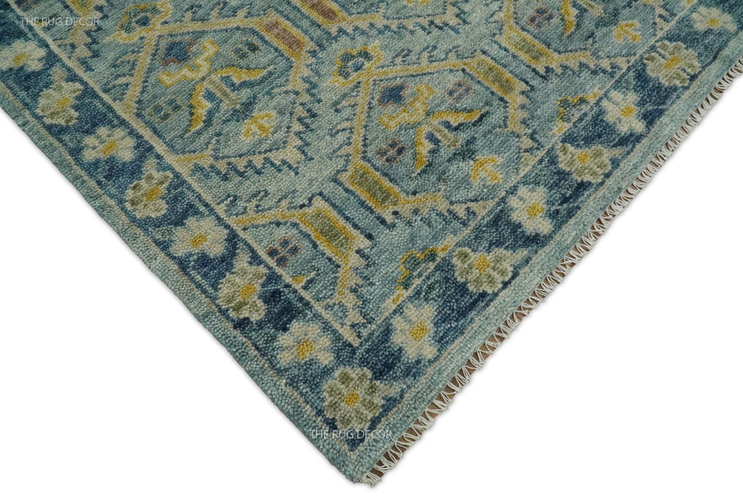 Rug corner showing its floral border, woven wool pile, and finished fringe edge