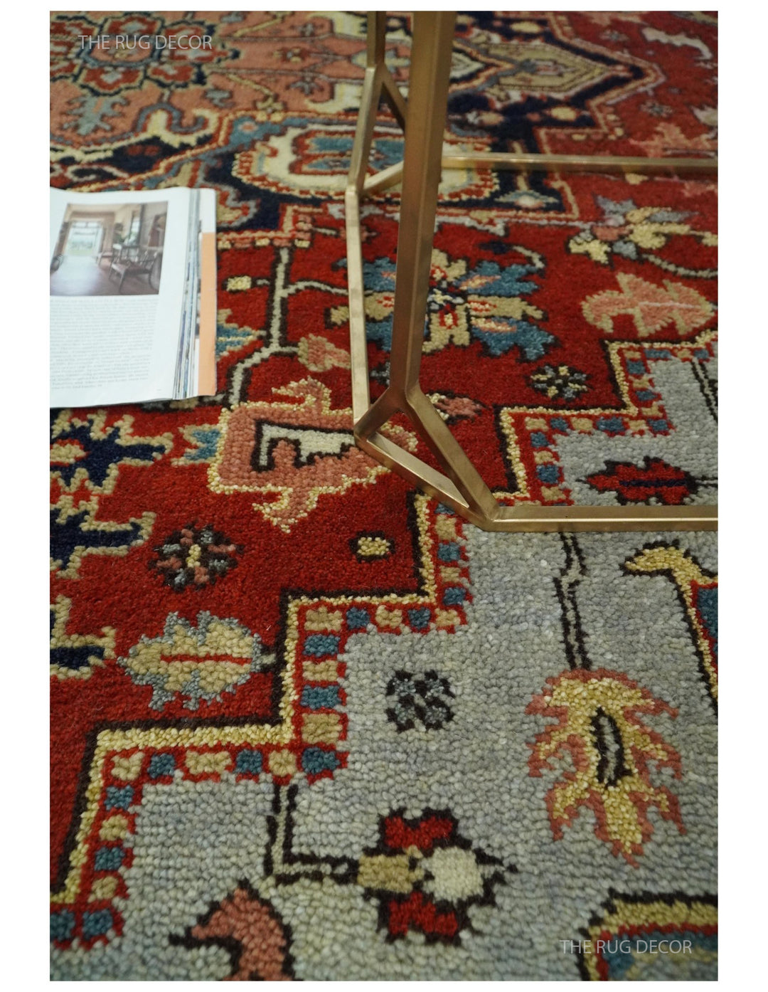 Hand-knotted wool rug corner detail with red field, navy accents, and decorative motifs
