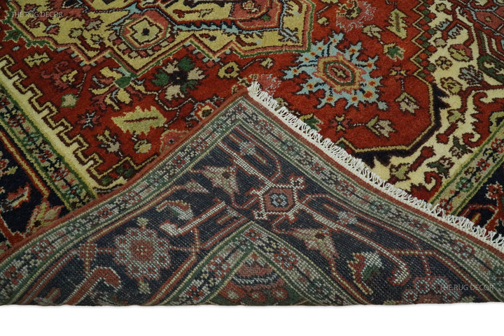 Close-up of rug border and medallion pattern in dark blue, rust red, cream, and green accents