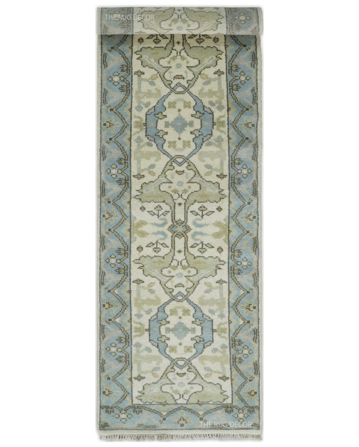 Runner rug laid flat, showing its ivory field, blue borders, and repeating medallions