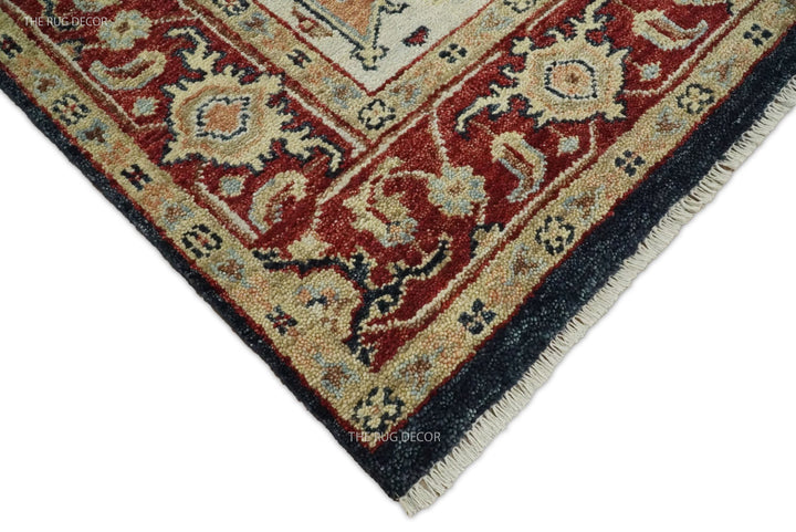 Rug corner detail with a red floral border, dark blue edging, and cream fringe