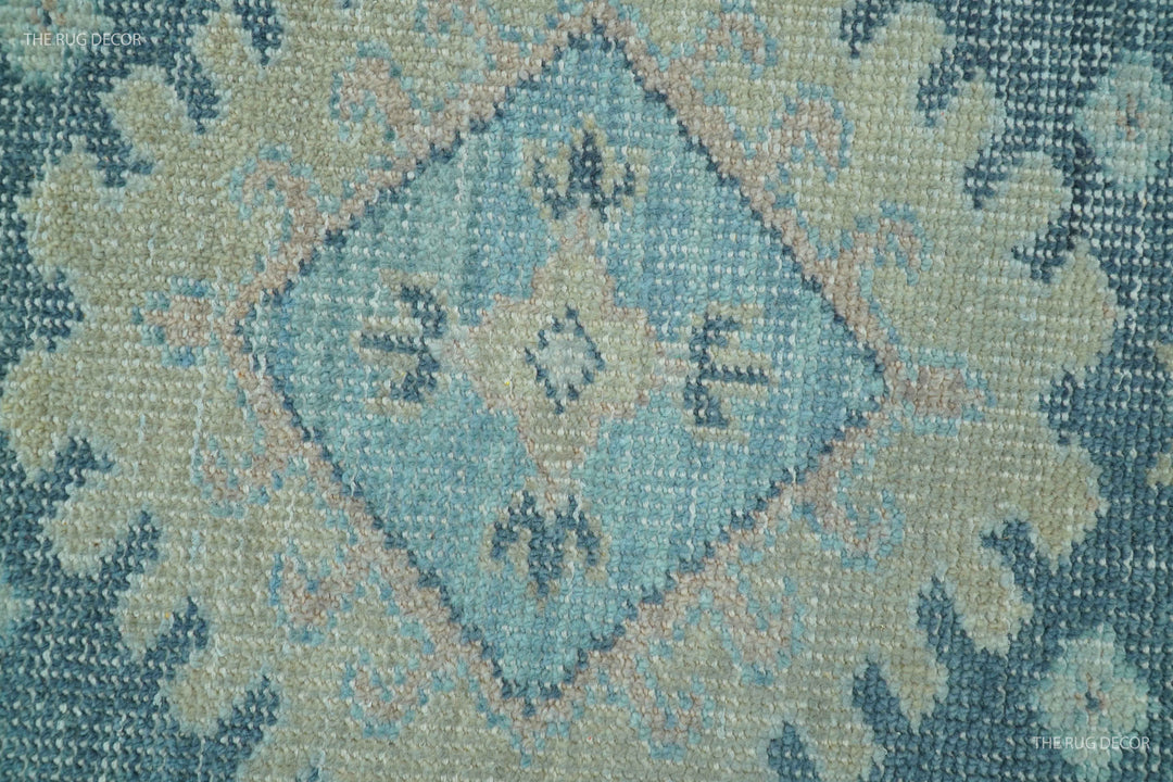 Close-up of hand-knotted wool rug texture with blue and beige diamond motifs