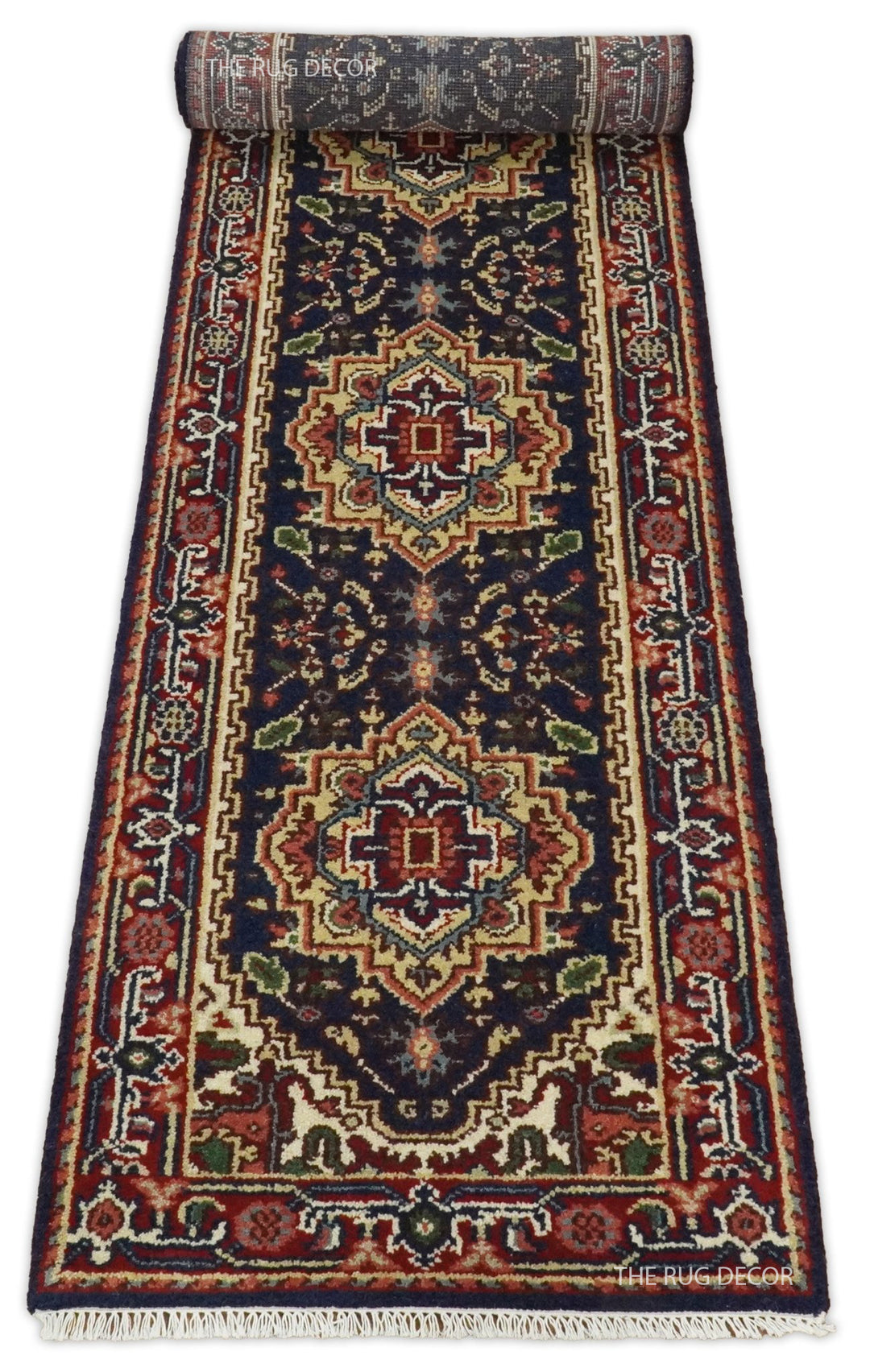 Partially rolled red and dark blue wool runner with geometric medallions and fringe